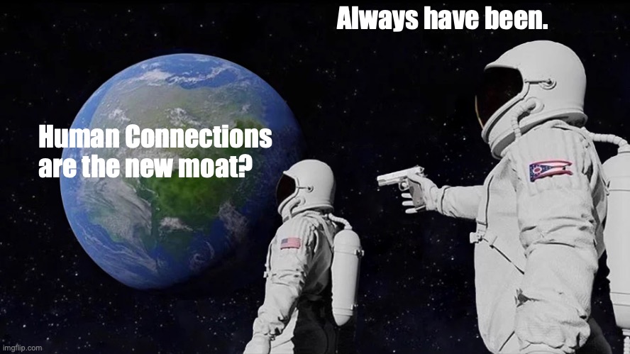 meme of two astronauts looking at Earth from space. The one closer to Earth is saying, "Human Connections are the new moat?" The second astronaut is standing behind the first holding a gun pointing at the head of the first astronaut saying, "Always have been."